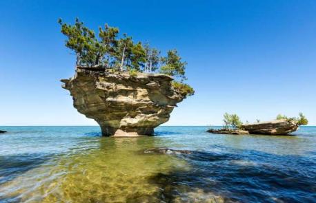Turnip Rock, Michigan: Twenty-foot-tall trees sprout from this unusual rock formation in Port Austin. Thought to resemble a turnip due to its squat shape and the generous greenery on its surface, the rock has been formed by the wear and tear of the waves over millennia. You can rent kayaks from the mainland and paddle out to see the structure (since much of its surrounding land is private, it's not possible to see if from the shore).The round trip is seven miles, so best suits those with some kayaking experience. Do you have any type of unusual tree (or rock) formations in the area where you live?
