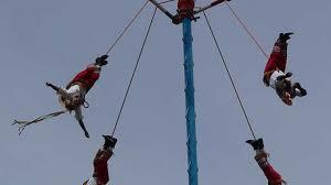 As far as marking the winter solstice, Mexico and Guatemala's Danza dos Voladores is not for the faint of heart. Basically, five men free climb a 30 m pole, and attach ropes around their ankles. Then four of them launch themselves into the air, descending to the ground on the end of the ropes as they unravel – while the last man dances slowly perched at the very top, playing the flute or drums: It is traditionally held on December 21, a significant date in the Maya Long Count Calendar. Have you ever seen this done?