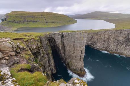 Lake Sørvágsvatn, Faroe Islands - Isolated in the North Atlantic Ocean, between Iceland and Norway. This long winding lake tumbles into the Atlantic Ocean via a waterfall. When a photo is taken from the right angle, the steep cliff makes it appear to be hundreds and hundreds of feet