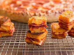 Bake into Croutons. Place two pizza slices together so the topping sides touch, then cut into squares. Drizzle a pan with olive oil then, cook the pizza in the pan over medium heat until toasted. Flip and repeat, then serve immediately on top of your favorite salad or soup.