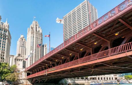Illinois: DuSable Bridge - Spanning the Chicago River in the heart of the Windy City, this striking structure is also known as the Michigan Avenue Bridge, as it extends this boulevard across the water. But, since 2010, the official name of this structure has been the DuSable Bridge, after Jean Baptiste Point du Sable, thought to be Chicago's first permanent resident. Nestled among some of the city's tallest skyscrapers, it also opens up gracefully if large boats need to pass beneath it. Have you ever visited this bridge?